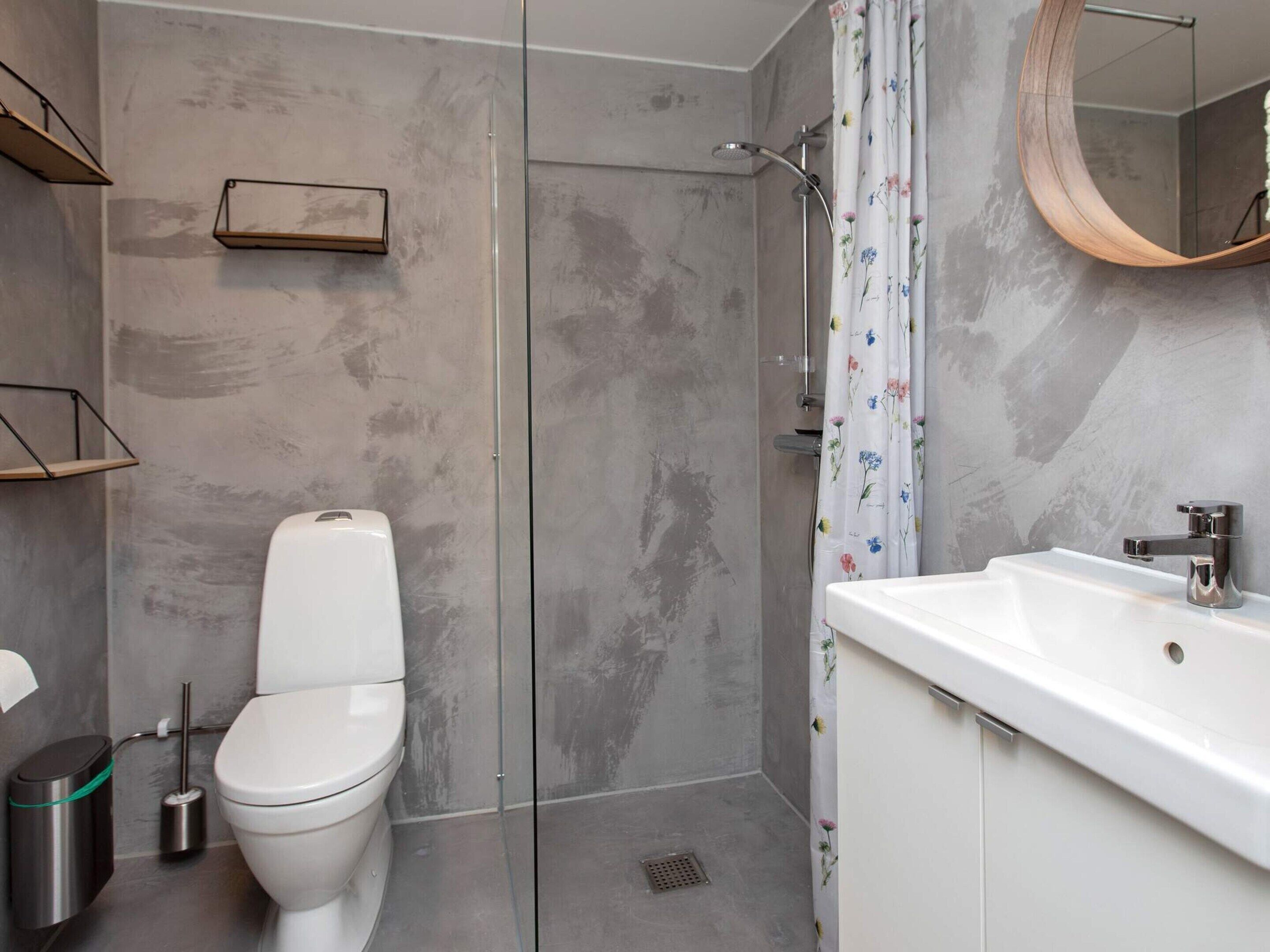 Une salle de bain moderne équipée d’une douche, de toilettes et d’un lavabo.