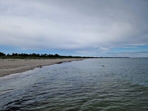 A beach with a sandy shore and calm water.