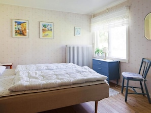A bedroom with a bed, a desk, a chair, and a radiator. - 4 Star Holiday Home in Bralanda (Bralanda)