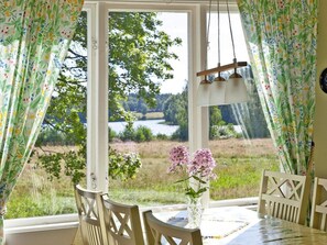 A dining area with a table, chairs, and a vase with flowers. - 4 Star Holiday Home in Bralanda (Bralanda)