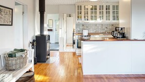 Una cocina con armarios blancos, una estufa negra y una cafetera.