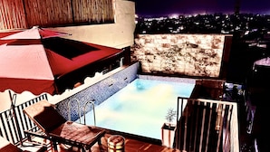 A rooftop pool area with a view of the city at night. - HOTEL EUPHORIA GREEN (Amritsar)