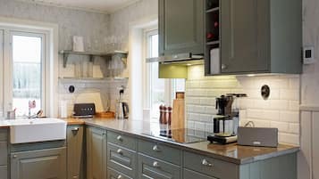 A modern kitchen with grey cabinets, a white countertop, and a built-in oven.