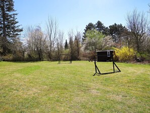 An outdoor area with two metal structures, possibly for sports or activities, surrounded by trees and grass. - 4 Person Holiday Home in Jaegerspris (Jægerspris)