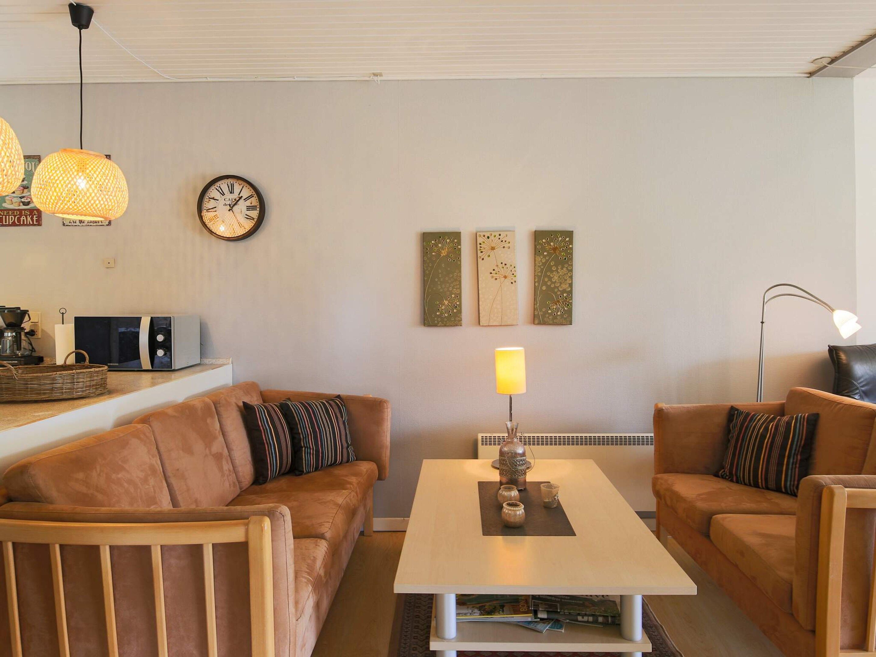Una sala de estar acogedora con un sofá, una mesita de centro y una lámpara.