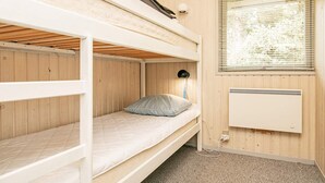 A bunk bed room with a window, a radiator, and a lamp. - 8 Person Holiday Home in Blavand (Blavand)