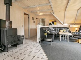 A cozy room with a fireplace, leather seating, and a tiled floor.