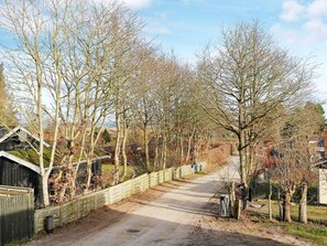 A rural road flanked by leafless trees and a wooden fence. - 4 Person Holiday Home in Hadsund (Hadsund)