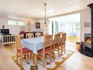 Una habitación acogedora con una mesa de comedor, sillas, un televisor y una chimenea.