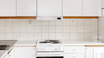 A kitchen with white cabinets, a white countertop, a Siemens range hood, and a white Electrolux stove.