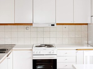 A kitchen with white cabinets, a white countertop, a Siemens range hood, and a white Electrolux stove.
