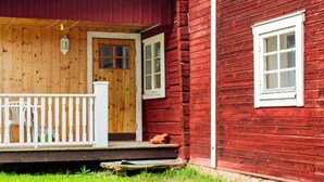 A wooden house with a porch, a door, and a window. - 4 Person Holiday Home in Tallberg (Tallberg)