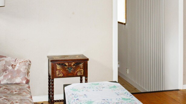 A room with a bed, a small wooden table, and a radiator. - 4 Person Holiday Home in Tallberg (Tallberg)