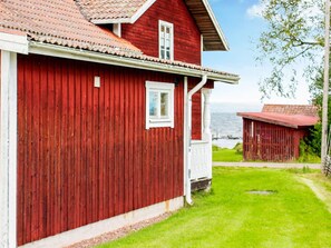 A red wooden house with a white porch and a window. - 4 Person Holiday Home in Tallberg (Tallberg)