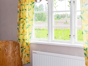 A room with a window, curtains, a radiator, and a wooden chair. - 4 Person Holiday Home in Tallberg (Tallberg)