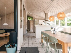 A modern kitchen with wooden cabinets, a central island, and pendant lighting. - 4 Star Holiday Home in Blavand (Blavand)