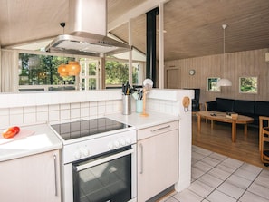 Une cuisine moderne équipée d’une cuisinière, d’un four et d’un coin repas avec une table et des chaises.