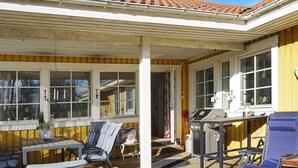 A covered patio with a grill, outdoor seating, and a view of the house. - 4 Star Holiday Home in Grebbestad (Grebbestad)