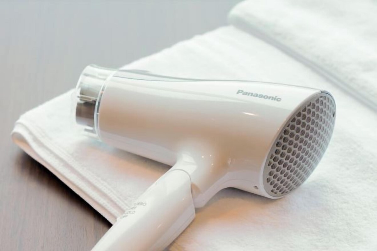 A Panasonic hair dryer on a white towel.