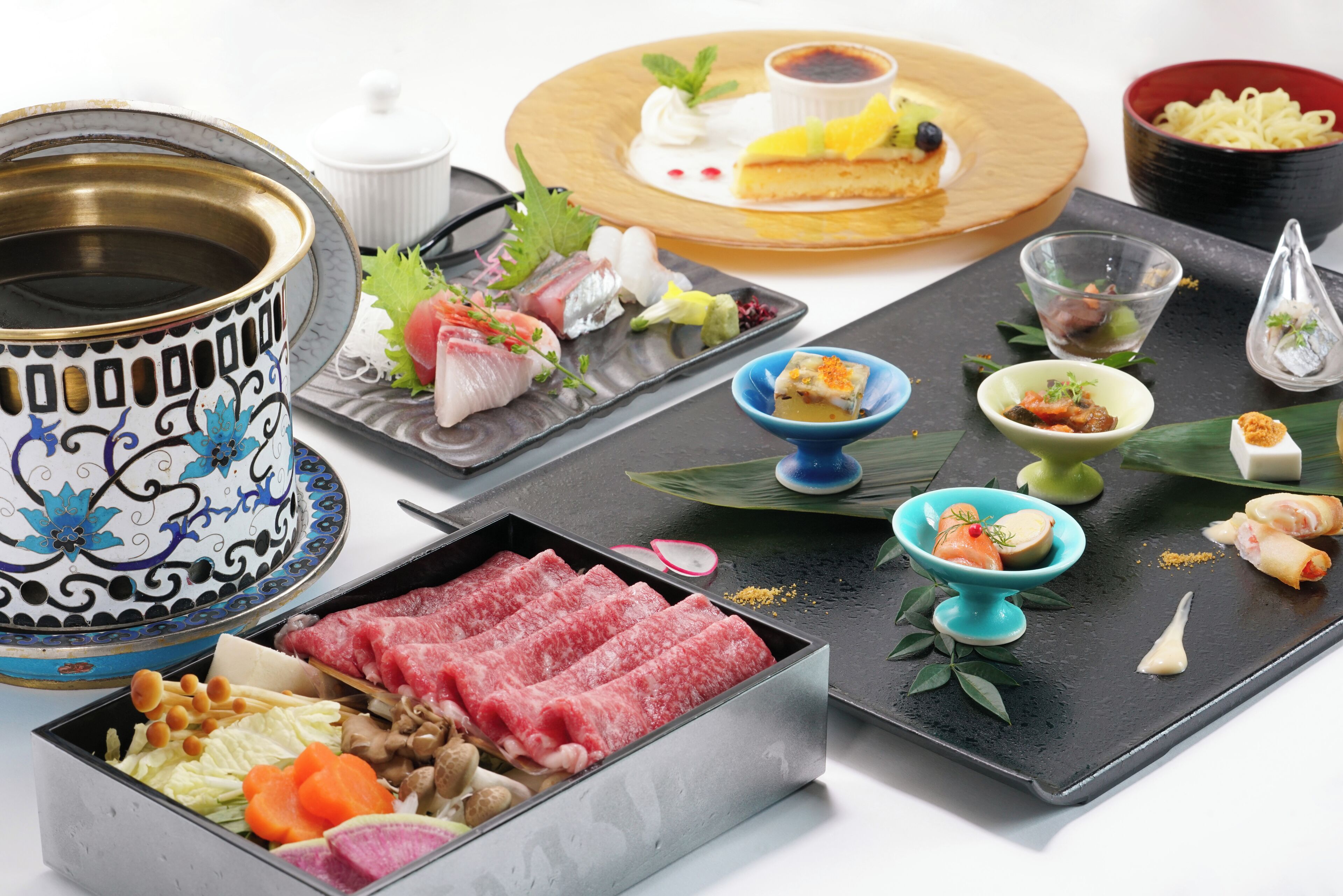 A variety of Japanese dishes including sashimi, sushi, and a hot pot.
