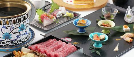 A variety of Japanese dishes including sashimi, sushi, and a hot pot.
