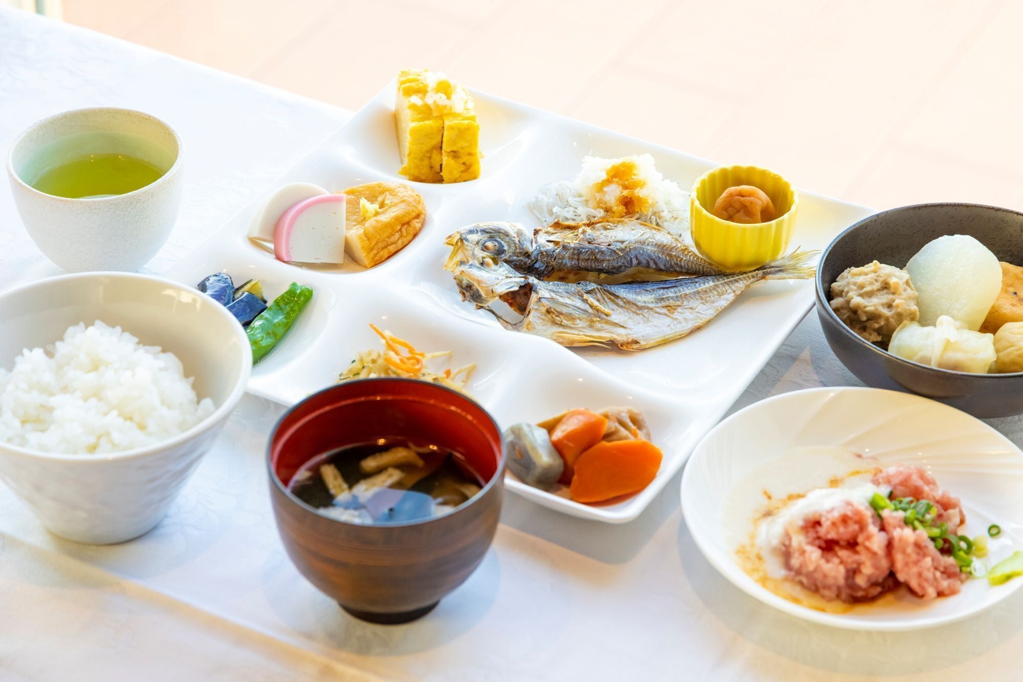 A variety of dishes including rice, fish, and vegetables, suggesting a meal setting.