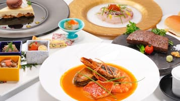 A variety of dishes on a table, including seafood, a dessert, and a meat dish.