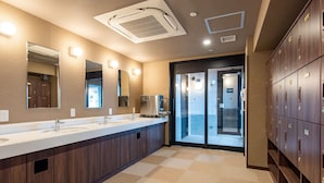 Ein modernes Hotelbad mit zwei Waschbecken, einem großen Spiegel und einer Glastür, die auf einen Balkon führt.
