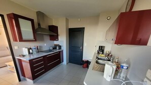 A compact kitchen with a stove, sink, and cabinets.