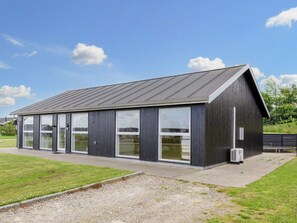 A modern building with a sloped roof and large windows.