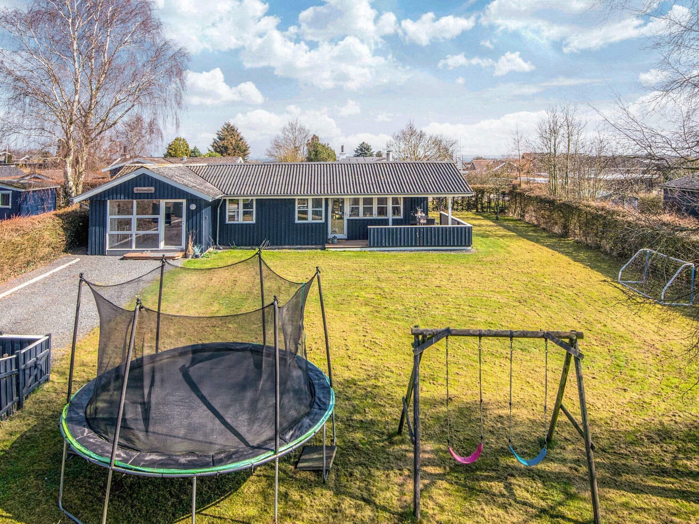 Il s’agit d’une propriété résidentielle comprenant une maison, un trampoline et un ensemble de jeux avec balançoire.