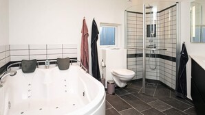 A modern bathroom with a freestanding bathtub, a glass-enclosed shower, and a toilet. - 4 Star Holiday Home in Laeso (Læsø)