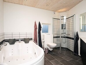 A modern bathroom with a freestanding bathtub, a glass-enclosed shower, and a toilet. - 4 Star Holiday Home in Laeso (Læsø)