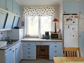 A compact kitchen with a window, a microwave, a coffee maker, and a refrigerator. - 5 Person Holiday Home in Stanga (Stånga)