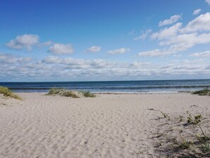 A sandy beach with gentle waves and a clear sky. - 5 Person Holiday Home in Stanga (Stånga)