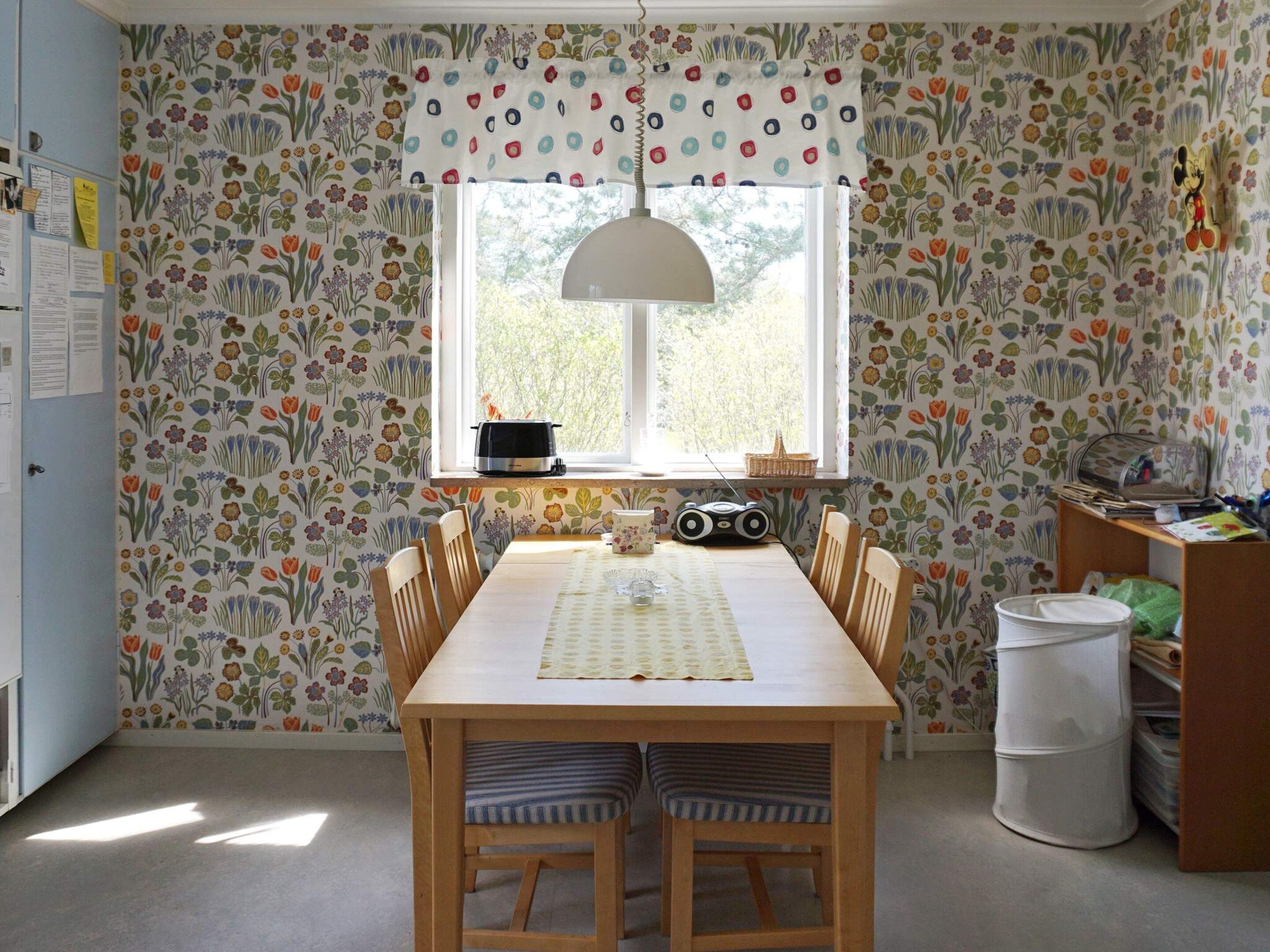 Een eetgedeelte met een tafel, stoelen, een raam en een radiator.