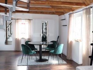A dining area with a round table, four chairs, and a modern chandelier. - 4 Star Holiday Home in Munka-ljungby (Munka-Ljungby)