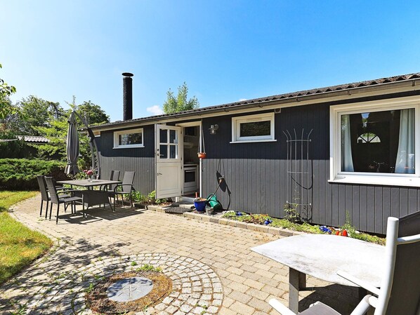 A residential building with a patio, a dining area, and a garage.