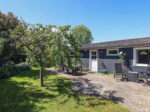A residential property with a paved driveway, outdoor seating area, and a garden. - 4 Person Holiday Home in Faxe Ladeplads (Faxe Ladeplads)
