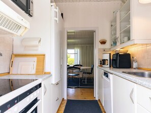 A compact kitchen with white cabinets, a microwave, a coffee maker, and a small sink. - 4 Person Holiday Home in Faxe Ladeplads (Faxe Ladeplads)