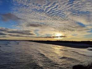 Um corpo de água refletindo a luz do sol, com o horizonte ao longe.