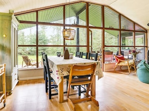 A dining area with a table set for four, large windows, and a view of the outdoors.