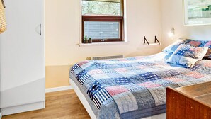 A bedroom with a bed, a window, a radiator, and a wall-mounted shelf. - 4 Star Holiday Home in Jerup (Jerup)