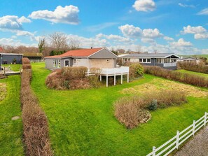 A residential area with houses, a grassy lawn, and a white fence. - 6 Person Holiday Home in Broager (Broager)