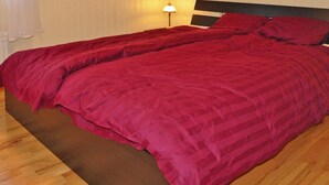 A double bed with a dark headboard and a red bedspread. - 4 Star Holiday Home in Mellerud (Mellerud)