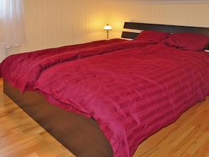 A double bed with a dark headboard and a red bedspread. - 4 Star Holiday Home in Mellerud (Mellerud)