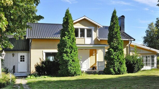 A two-story house with a front porch, a chimney, and a well-maintained lawn. - 4 Star Holiday Home in Mellerud (Mellerud)