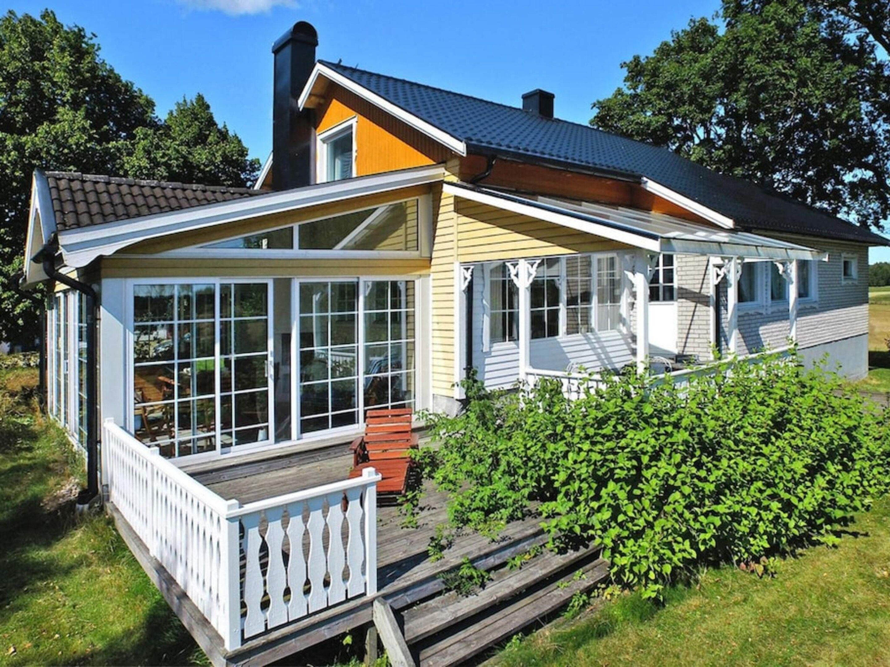 A two-story house with a covered porch and large windows.