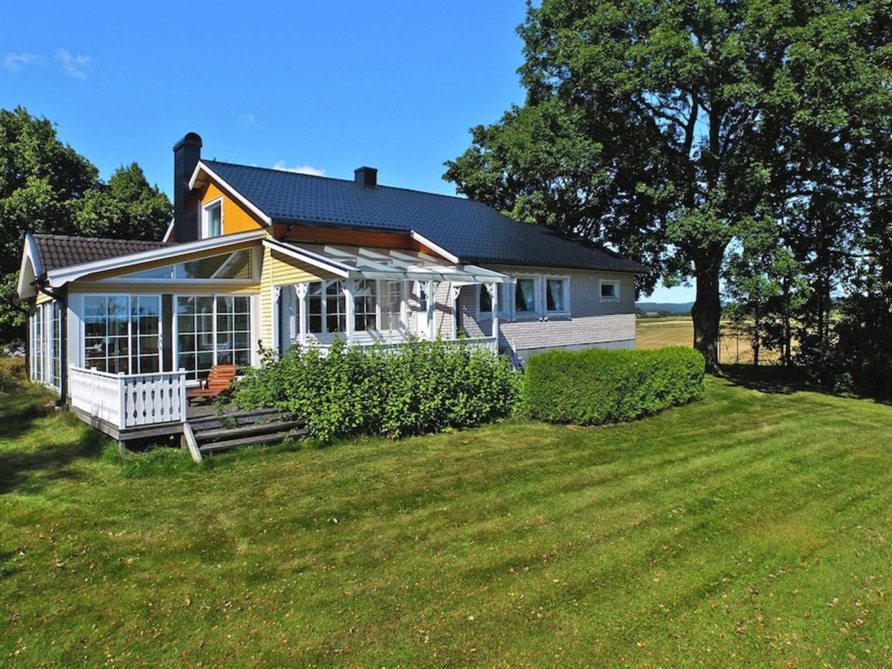 A two-story house with a covered porch, a visible chimney, and a well-maintained lawn.