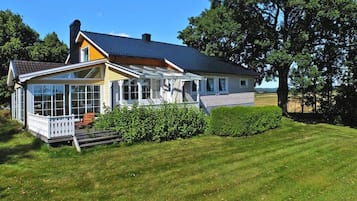 A two-story house with a covered porch, a visible chimney, and a well-maintained lawn.